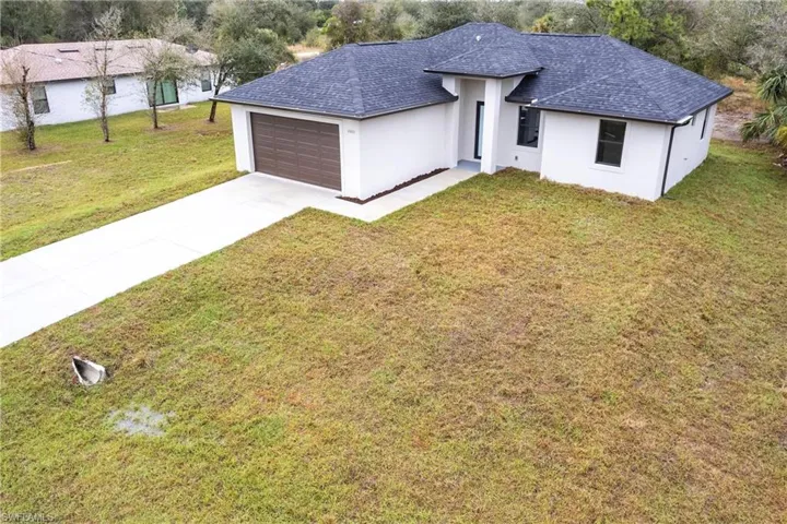 View of front of property featuring a garage and a front yard