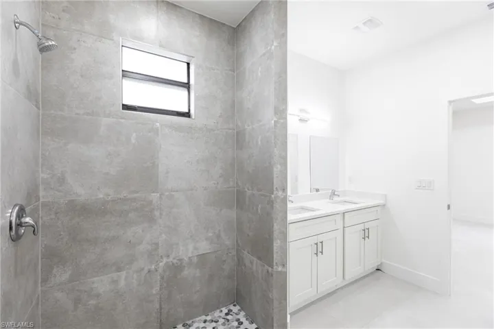 Bathroom featuring vanity and a tile shower