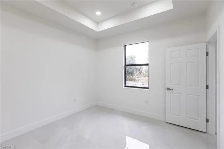 Empty room featuring a tray ceiling