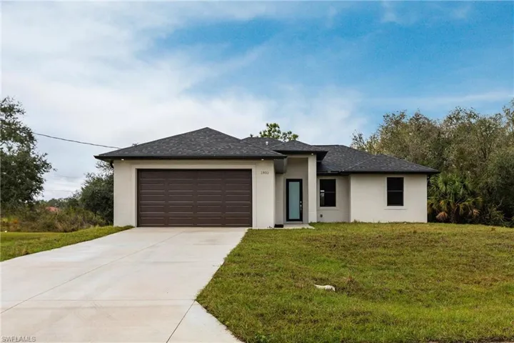 View of front of house with a front yard and a garage