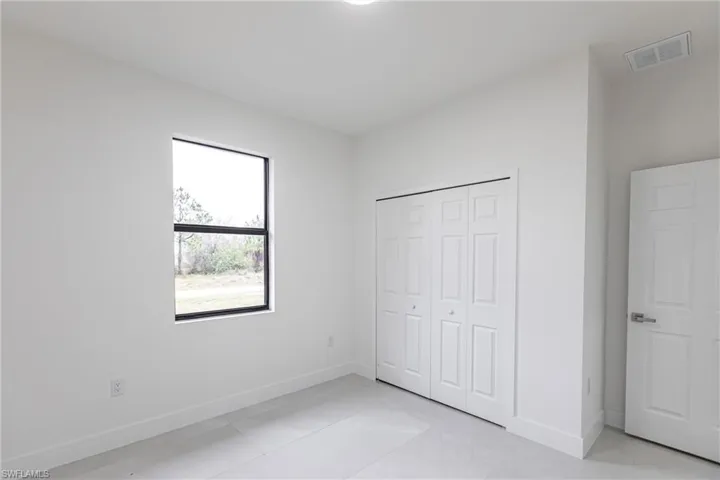 Unfurnished bedroom featuring a closet and light tile patterned floors