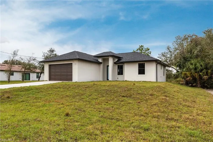 View of front of home with a garage and a front lawn