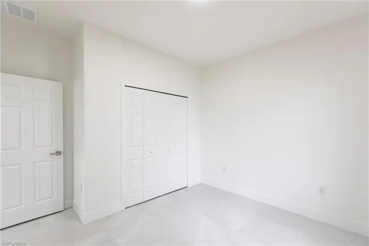 Unfurnished bedroom featuring a closet and light tile patterned flooring