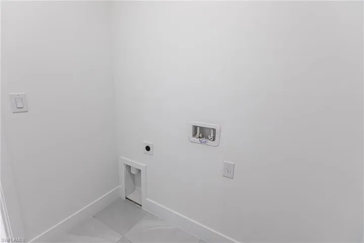 Clothes washing area featuring hookup for a washing machine, light tile patterned floors, and hookup for an electric dryer