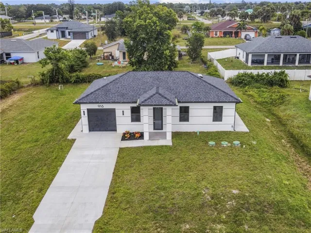 View of front of house with concrete driveway, a residential view, an attached garage, and stucco siding