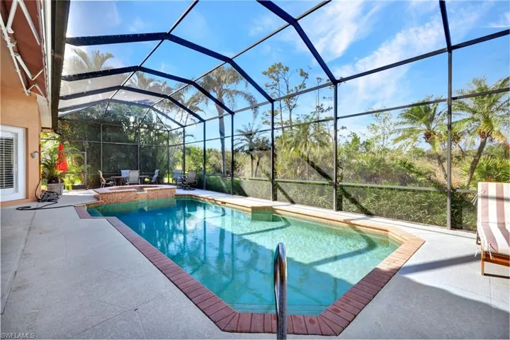 View of pool with a lanai, an in ground hot tub, and a patio