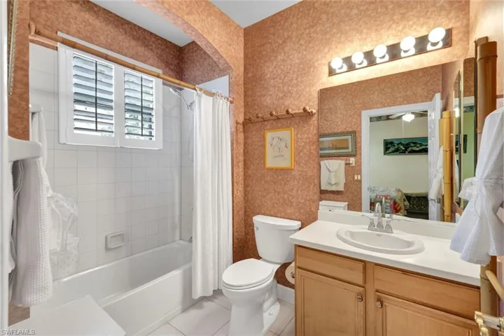 Full bathroom featuring tile patterned floors, vanity, toilet, and shower / tub combo with curtain