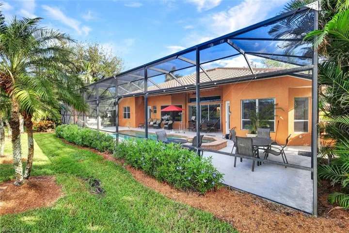Rear view of house with a patio, a lanai, and a pool with hot tub