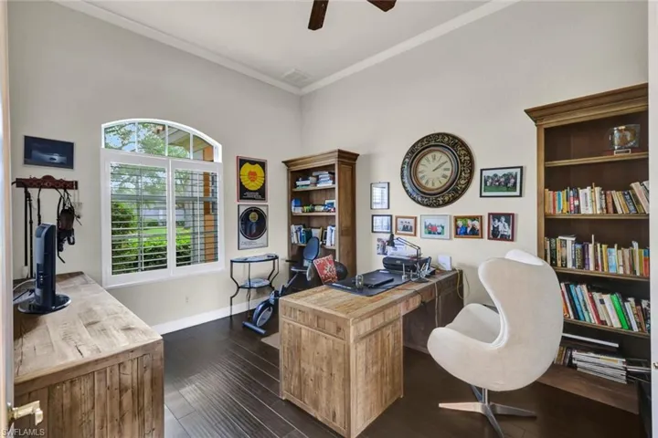Office area featuring ceiling fan, ornamental molding, and dark wood-type flooring