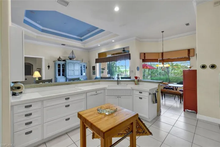 Kitchen featuring kitchen peninsula, dishwasher, sink, and white cabinets