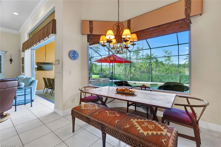 Dining area featuring a healthy amount of sunlight, light tile patterned flooring, ornamental molding, and a chandelier