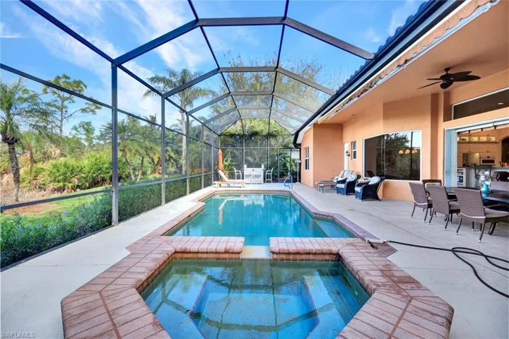 View of pool featuring a lanai, ceiling fan, a patio area, and an in ground hot tub