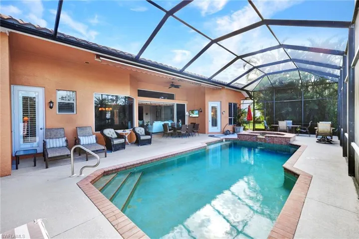 View of pool with a lanai, a patio area, ceiling fan, and an in ground hot tub