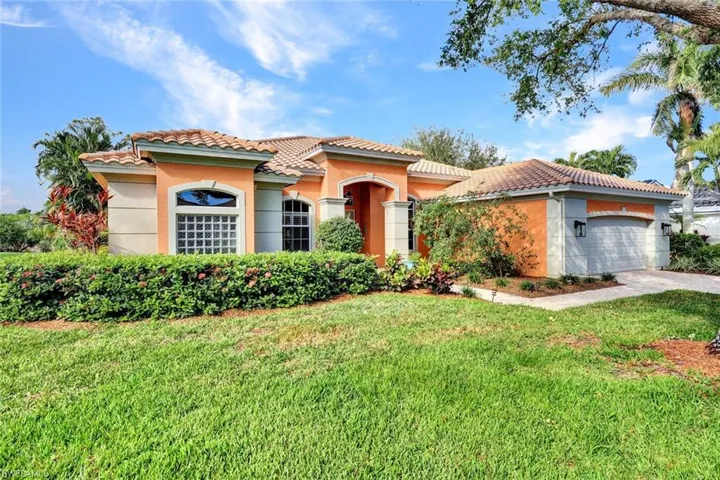 Mediterranean / spanish-style house with a garage and a front yard