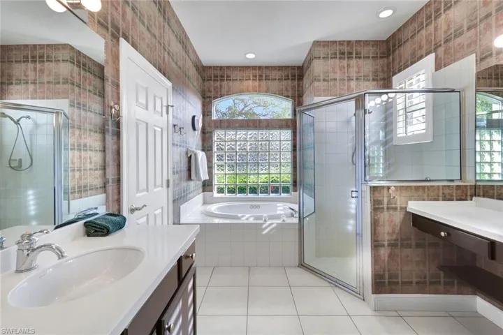 Bathroom featuring shower with separate bathtub and a wealth of natural light