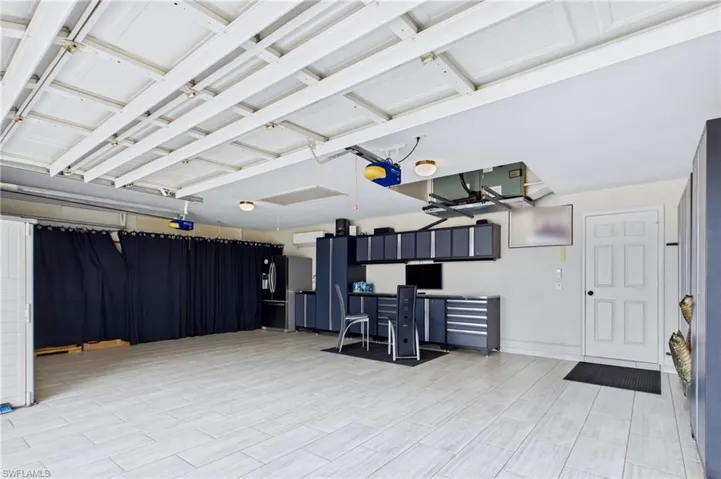 Spacious garage featuring light-toned tile flooring and organized storage solutions