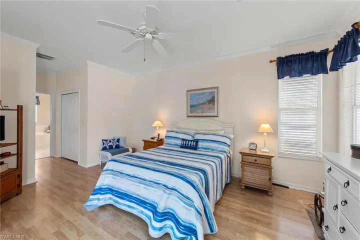 Bedroom featuring ceiling fan, a closet, light hardwood / wood-style floors, and ornamental molding