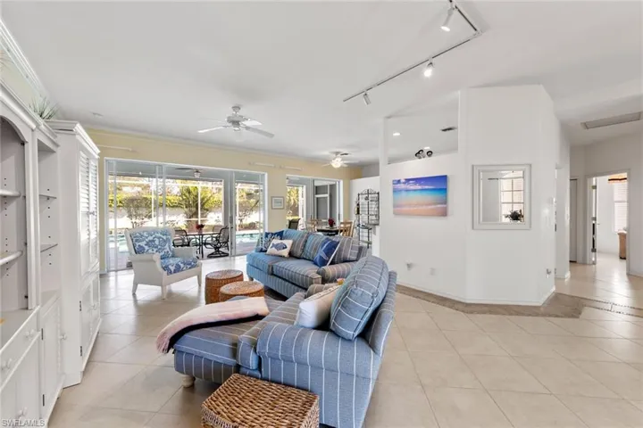 Tiled living room featuring ceiling fan, a healthy amount of sunlight, and rail lighting