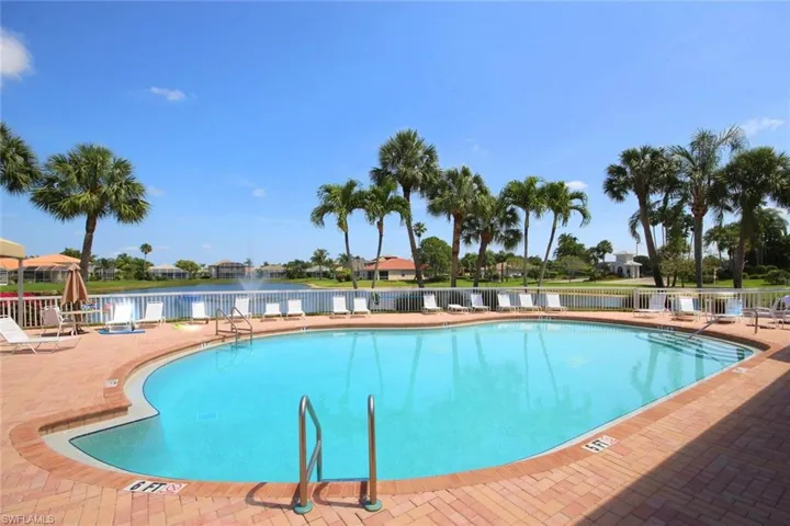 View of swimming pool with a water view and a patio