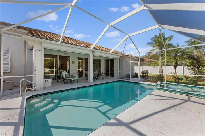 View of pool with a lanai, ceiling fan, and a patio