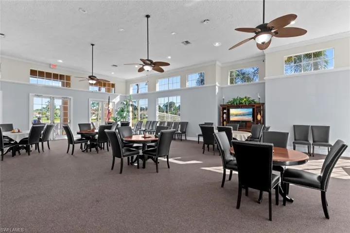 Carpeted dining room featuring ornamental molding, a textured ceiling, and a high ceiling