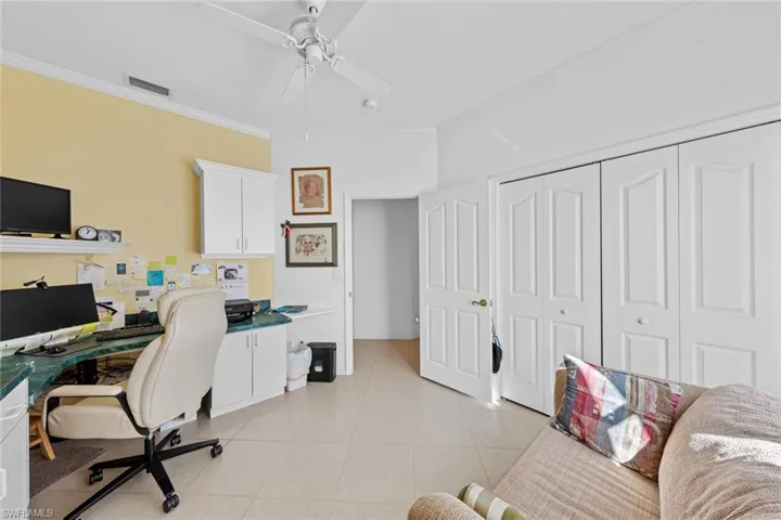 Tiled office space featuring crown molding and ceiling fan