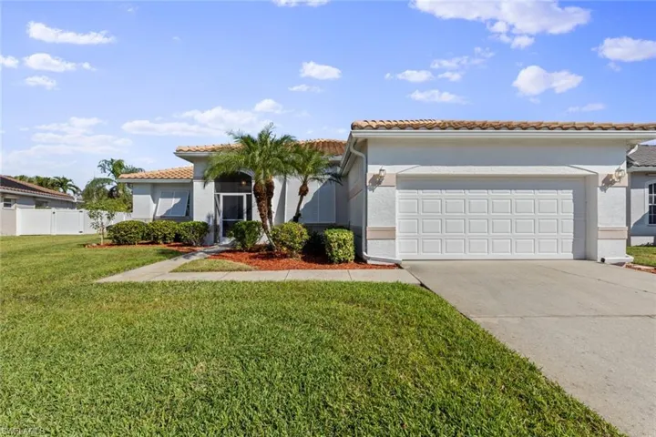 Mediterranean / spanish house with a front yard and a garage