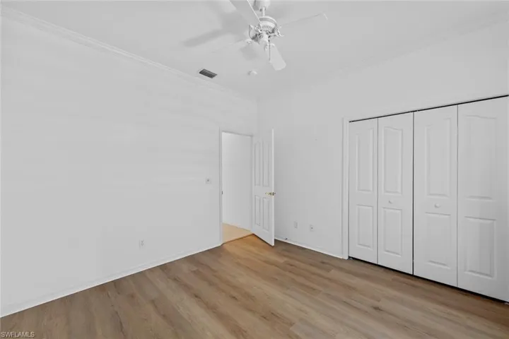 Unfurnished bedroom featuring light wood-type flooring, a closet, ceiling fan, and ornamental molding