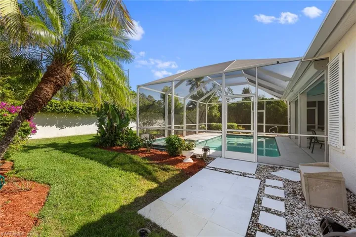 View of swimming pool featuring a lanai, a patio area, a yard, and a water view