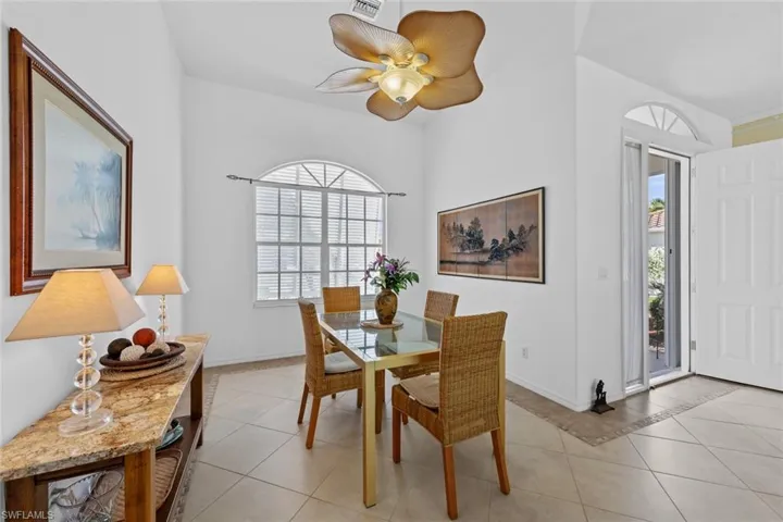 Tiled dining space featuring ceiling fan and a wealth of natural light