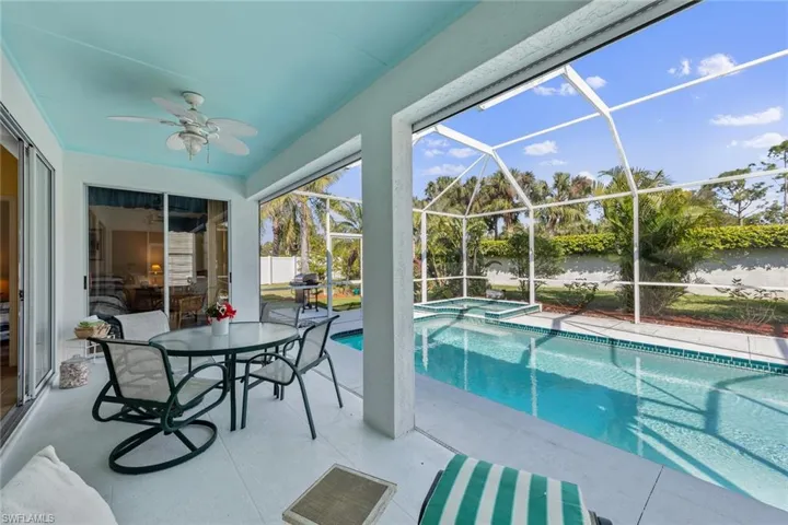 View of pool with ceiling fan, a patio area, and glass enclosure