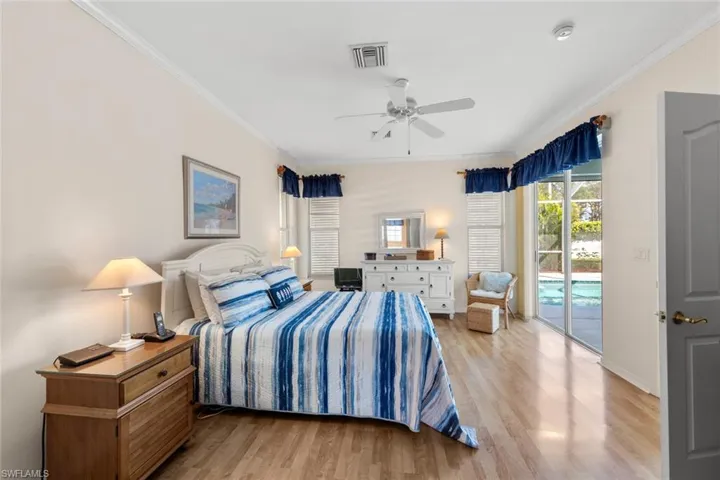 Bedroom featuring access to exterior, light wood-type flooring, ceiling fan, and ornamental molding