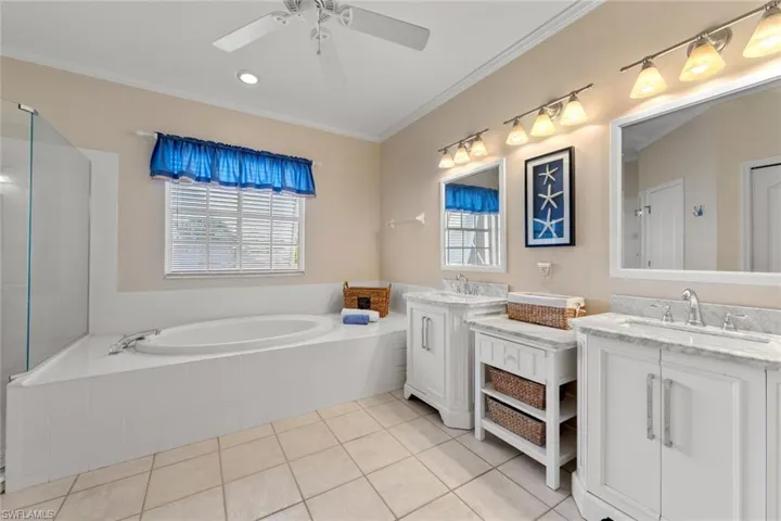 Bathroom with tile patterned floors, ceiling fan, a healthy amount of sunlight, and ornamental molding