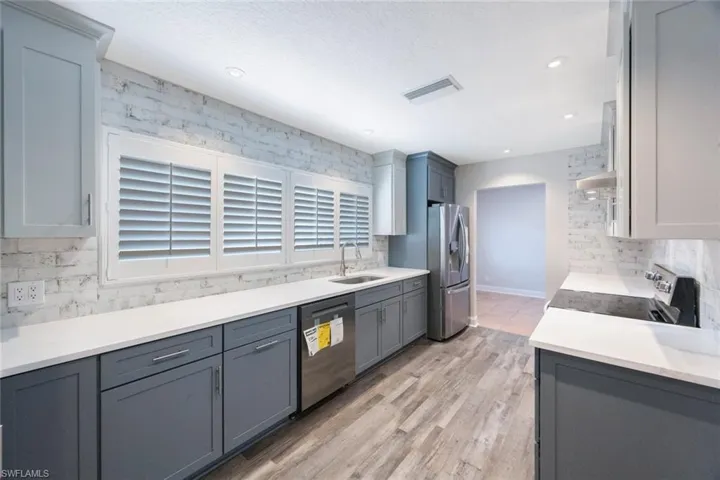 Kitchen featuring visible vents, appliances with stainless steel finishes, decorative backsplash, and a sink