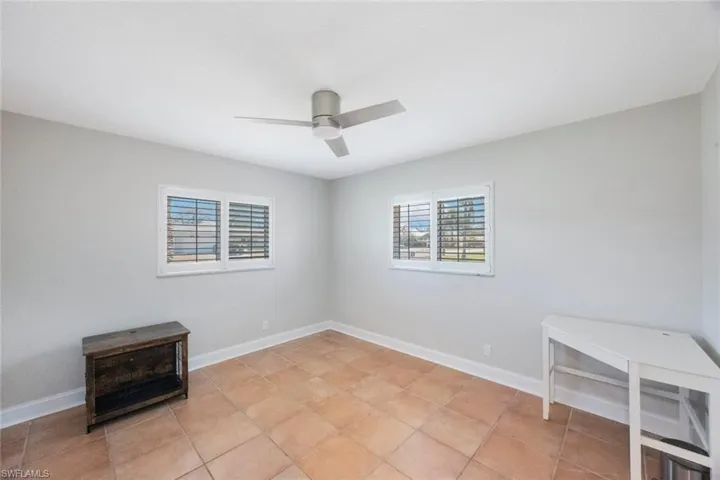 Empty room with a ceiling fan and baseboards