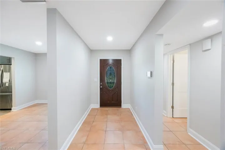 Doorway to outside featuring light tile patterned floors, recessed lighting, and baseboards