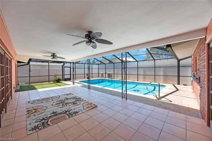 View of swimming pool featuring a lanai, a patio area, a ceiling fan, and a fenced in pool