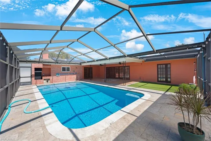 Pool featuring french doors, a ceiling fan, glass enclosure, and a patio area