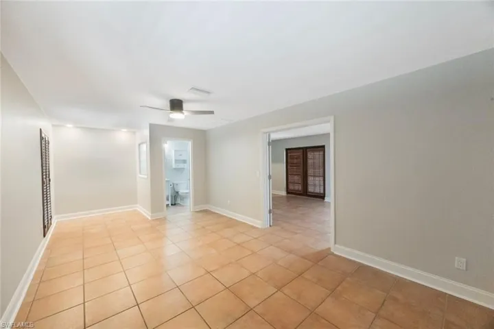 Unfurnished room featuring ceiling fan, visible vents, baseboards, and light tile patterned flooring