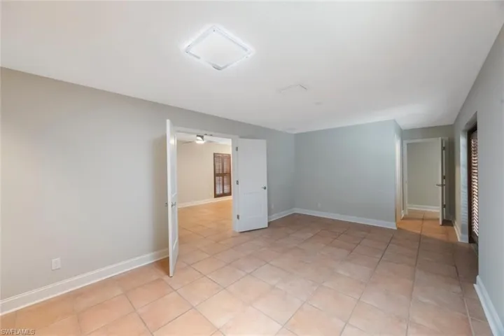 Empty room with light tile patterned floors and baseboards