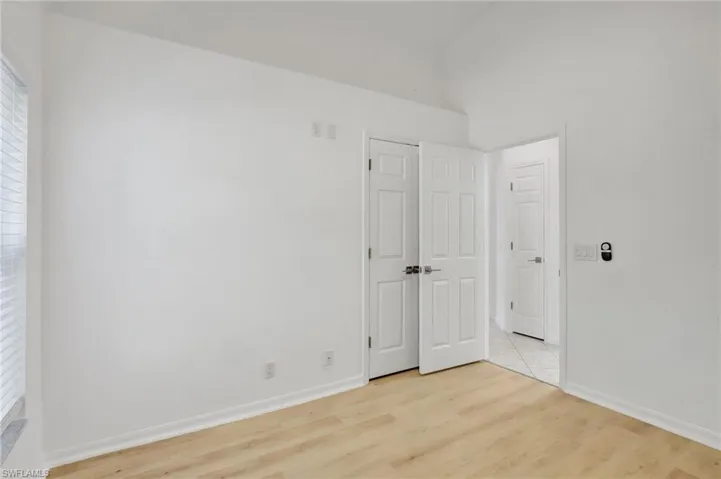 Unfurnished bedroom featuring multiple windows and light wood-type flooring