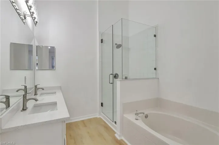 Bathroom featuring vanity, hardwood / wood-style floors, and separate shower and tub