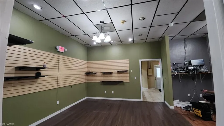 Empty room featuring wood finished floors, baseboards, recessed lighting, and a chandelier