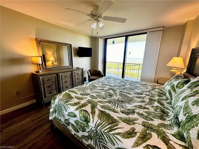 Bedroom featuring access to outside, dark wood-style flooring, and a ceiling fan
