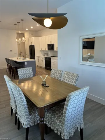 Open-concept kitchen and dining area featuring a contemporary pendant light fixture