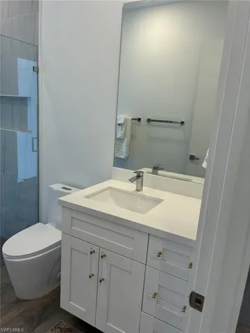 Modern bathroom featuring a white vanity with an integrated sink, polished chrome faucet, and a large wall-mounted mirror