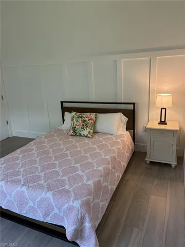 Wood-finish flooring in a light tone, white board and batten wall detailing, and a neutral wall color