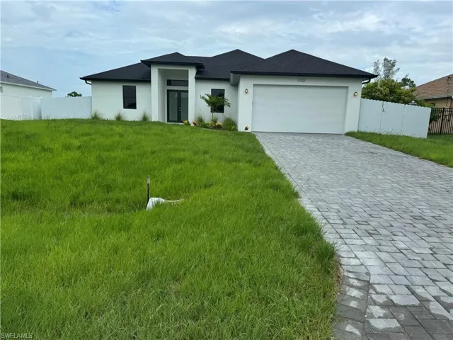 View of front facade with a garage and a front lawn