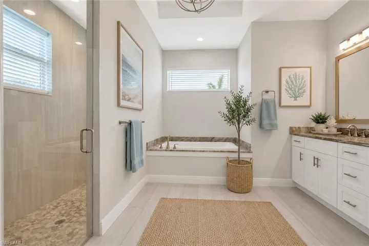 Owner's bath with dual vanities, matching granite counters, soaking tub and walk in shower, virtually staged