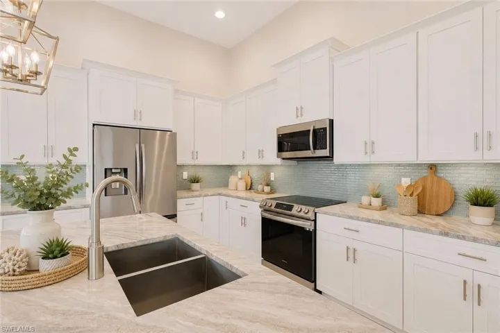 Island kitchen with granite counters, classic white shaker style cabinets with crown molding and crown molding. Virtually staged.